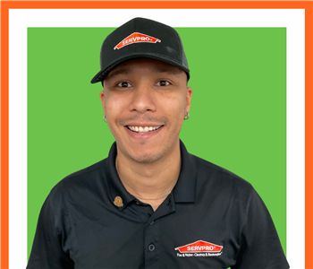 Jose, SERVPRO employee in uniform in front a white background, posed with arms crossed