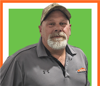 Kevin, SERVPRO employee male, in front of white background and green servpro sign